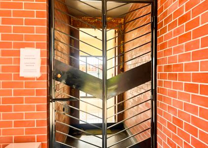 Black steel gate framed by red bricks